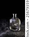 Empty decanter with smoke on black background 25679359