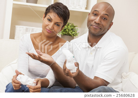 African American Couple Playing Video Console Game African American Couple Playing Video Console Game 25680628