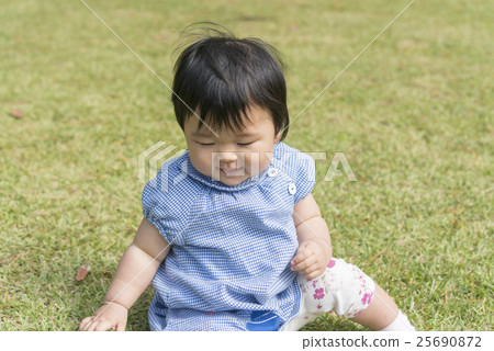 有微笑的嬰孩在草坪使用 有微笑的嬰孩在草坪使用 25690872