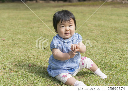 有微笑的嬰孩在草坪使用 有微笑的嬰孩在草坪使用 25690874