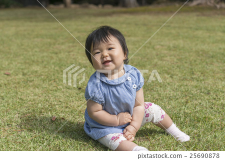 有微笑的嬰孩在草坪使用 有微笑的嬰孩在草坪使用 25690878