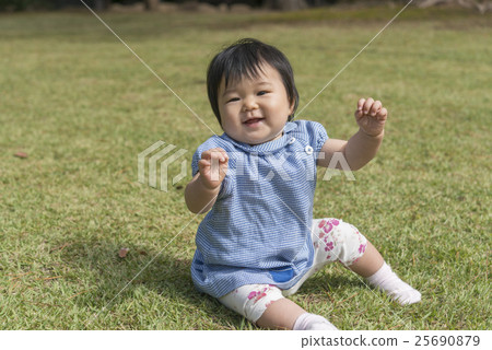 有微笑的嬰孩在草坪使用 有微笑的嬰孩在草坪使用 25690879