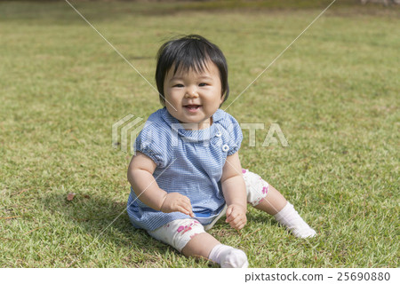 有微笑的嬰孩在草坪使用 有微笑的嬰孩在草坪使用 25690880