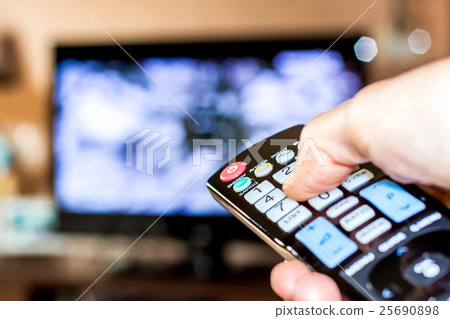 Hand hold the remote control to change tv channel Hand hold the remote control to change tv channel 25690898