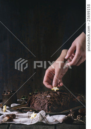 Decorating of christmas chocolate yule log 25699158