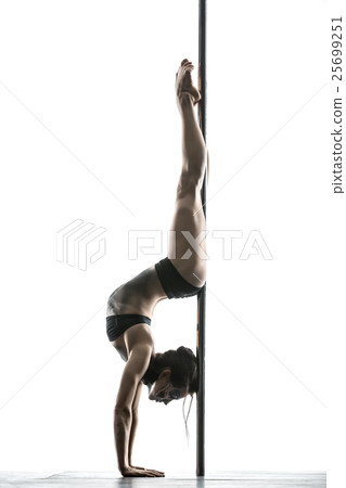 Female pole dancer posing in studio 25699251