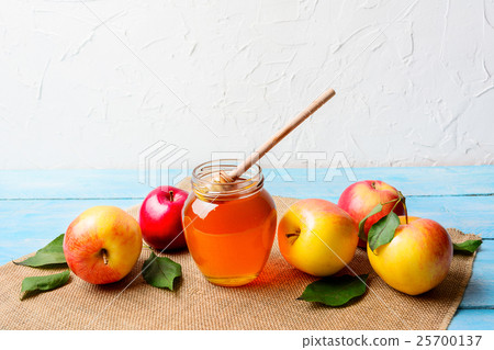 Glass honey jar with dipper and apples copy space Glass honey jar with dipper and apples copy space 25700137