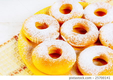 Icing homemade donuts on yellow plate 25700141