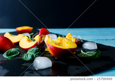 Slices of ripe nectarines and peach on black stone Slices of ripe nectarines and peach on black stone 25700400