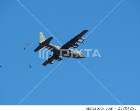 Transport aircraft flying in the blue sky at the beginning of descent training to be held in the new spring at Narashino garrison in Funabashi City, Chiba Prefecture and falling umbrella 25704253