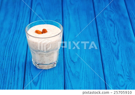 Banana and almond milk smoothie in a glass, blue Banana and almond milk smoothie in a glass, blue 25705910
