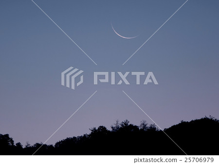 A thin moon rising from the mountains before dawn 25706979