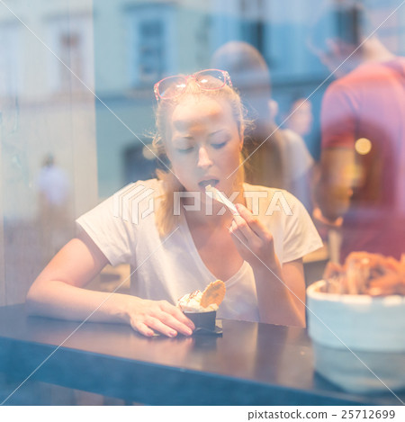 Young pretty woman eating icecream in gelateria. Young pretty woman eating icecream in gelateria. 25712699