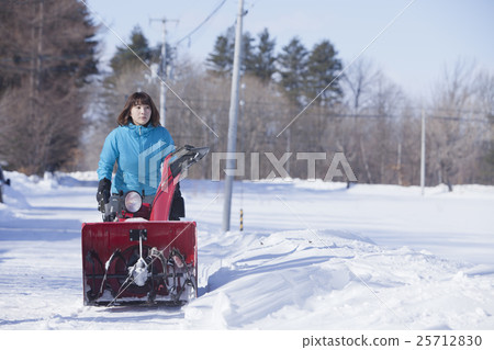 A woman snow removing 25712830