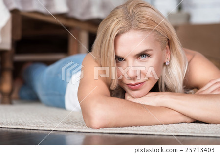 Close up of blond woman lying on floor Close up of blond woman lying on floor 25713403
