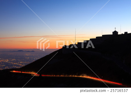 Light trails with building in silhouette. 25716537