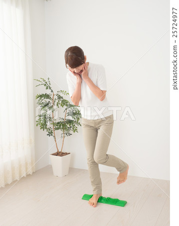 A woman with a pain in stepping on a bamboo 25724977