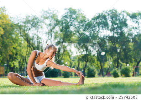 woman doing yoga in the park 25742505