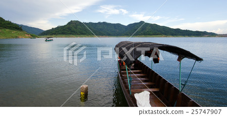 A fishing boat tied at the shore at Khun Dan dam A fishing boat tied at the shore at Khun Dan dam 25747907