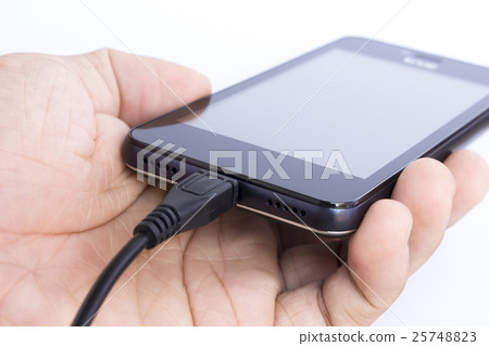 human's hand holding smart phone is charging 25748823