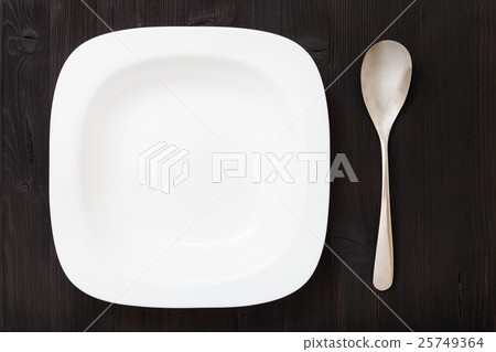 top view white bowl with spoon on dark brown table top view white bowl with spoon on dark brown table 25749364