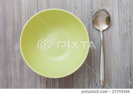 top view of green bowl and on gray brown tabl 25749366