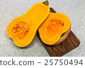 Squash cut in half on a wooden board 25750494