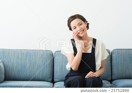 A woman sitting on a sofa (in her twenties) 25752899