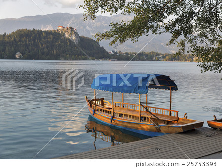 Boat on lake Bled overlooked by castle at sunset. 25753393