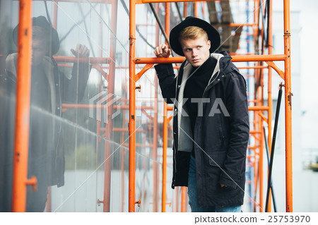 Young man posing with a trendy outfit against 25753970