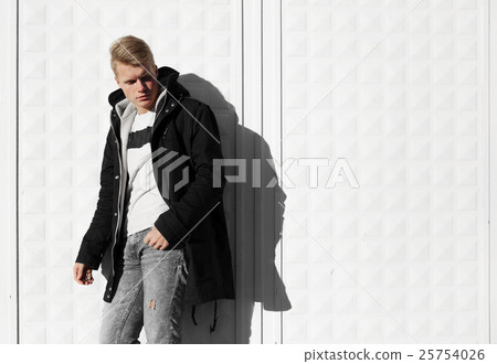Young blonde man in autumn clothes standing near Young blonde man in autumn clothes standing near 25754026