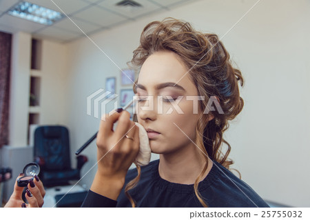 Make up artist doing professional eye makeup of 25755032