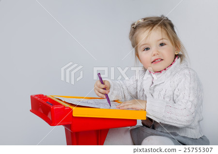 Smiling little girl at the table draw 25755307
