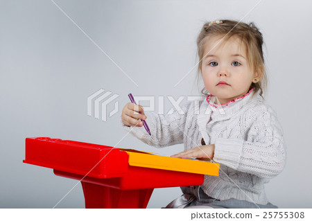 Smiling little girl at the table draw 25755308