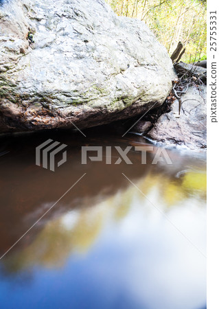river beside a large boulder 25755331