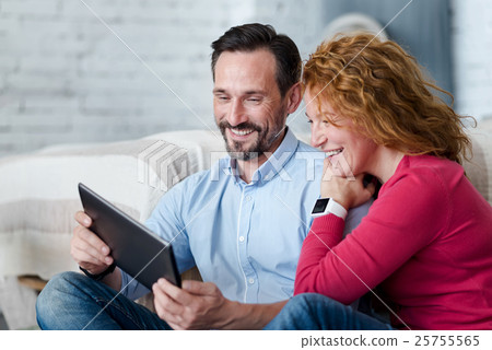 Middle-aged couple using tablet at home Middle-aged couple using tablet at home 25755565