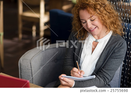 Top view of smiling woman taking notes Top view of smiling woman taking notes 25755698