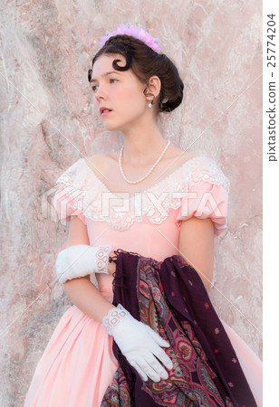 Romantic girl stands near a wall of pink stone Romantic girl stands near a wall of pink stone 25774204