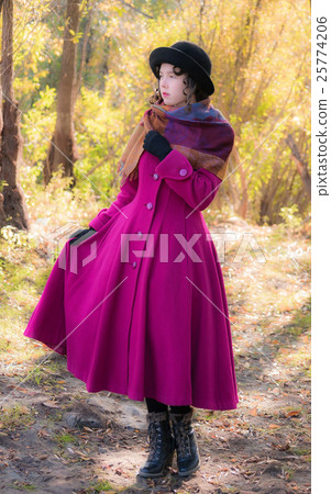 Girl in a bright crimson coat and a black hat Girl in a bright crimson coat and a black hat 25774206