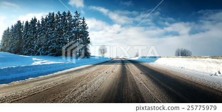 Asphalt road in snowy winter on beautiful sunny 25775979