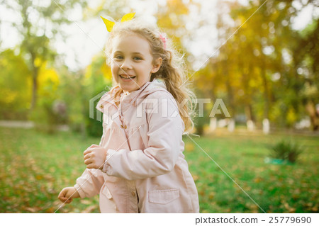 Happy child girl having fun in autumn park Happy child girl having fun in autumn park 25779690
