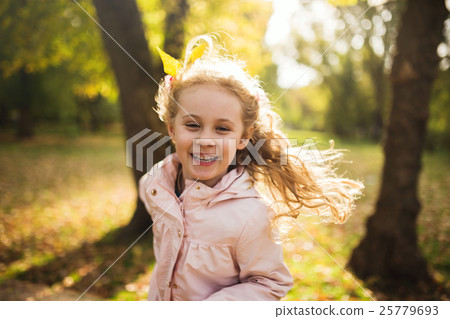 Happy child girl having fun in autumn park Happy child girl having fun in autumn park 25779693