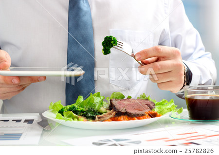 Businessman working during business lunch Businessman working during business lunch 25782826