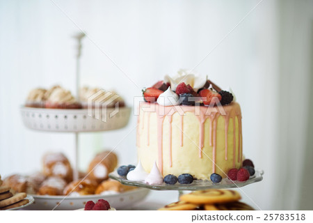 Cake with various berries and meringues on a stand 25783518