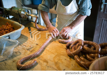 Man making sausages the traditional way using 25783617