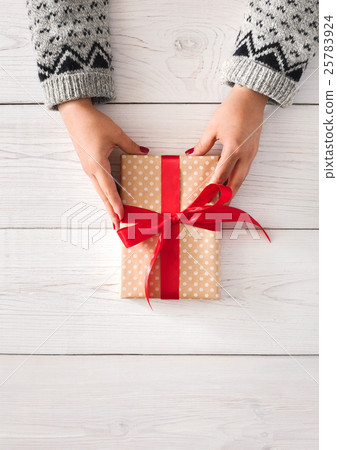 Woman's hands give christmas gift in present box Woman's hands give christmas gift in present box 25783924