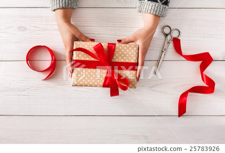 Woman's hands give christmas gift in present box Woman's hands give christmas gift in present box 25783926