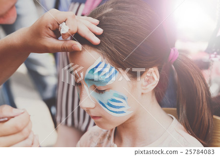 Female child face painting, making butterfly Female child face painting, making butterfly 25784083