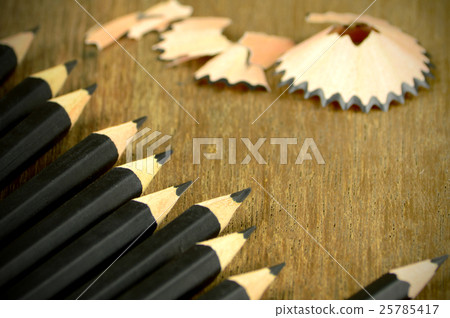 Sharped Black Pencils on wooden Background. 25785417