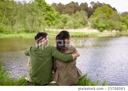 happy couple hugging on lake or river bank happy couple hugging on lake or river bank 25788083